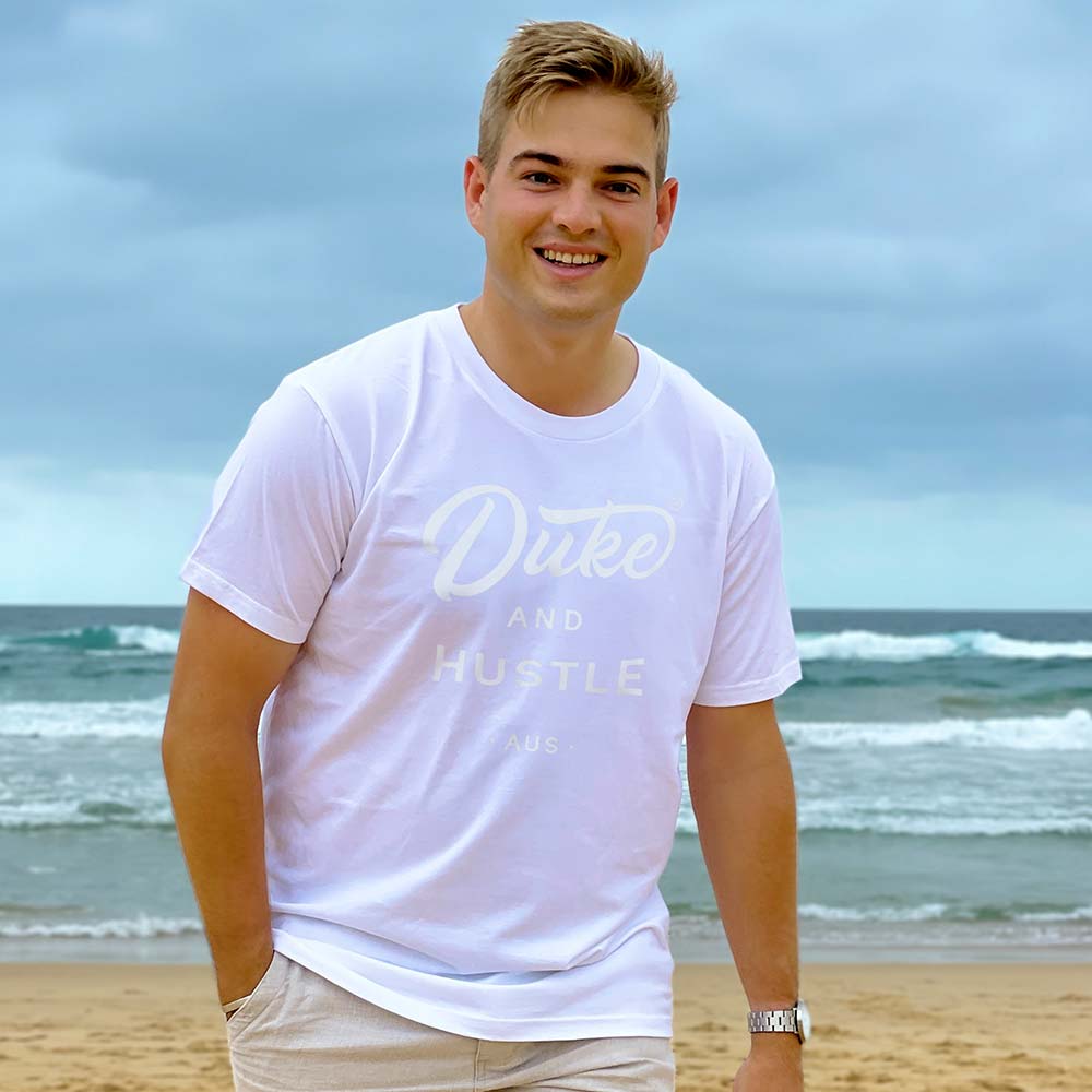 Tim, wearing a white classic fit unisex tee, featuring The Flat White Series