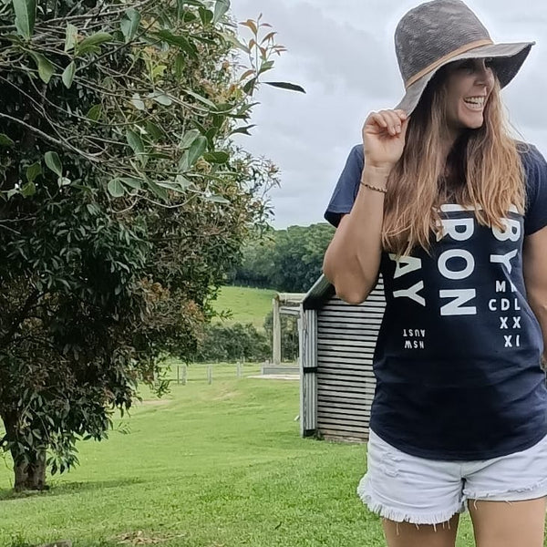 A model wears our Byron Bay women's navy long curve tee, while at The Farm Byron Bay
