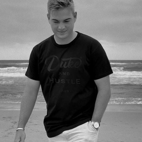 Front side, Black Duke & Hustle Logo on Black Classic Fit Cotton Tee, worn by Tim