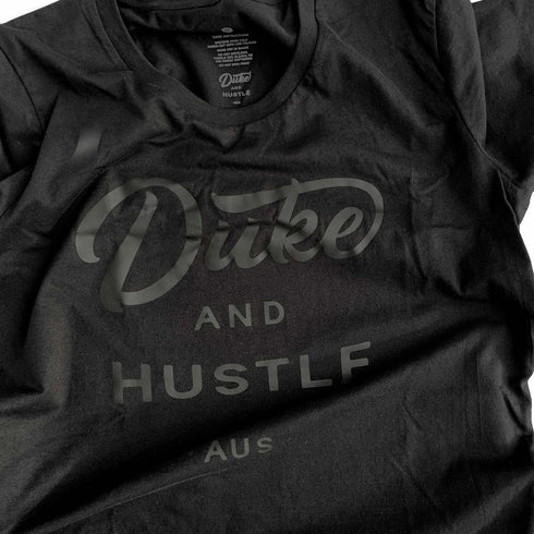 Front side, Black Duke & Hustle Logo on Black Classic Fit Cotton Tee, close up