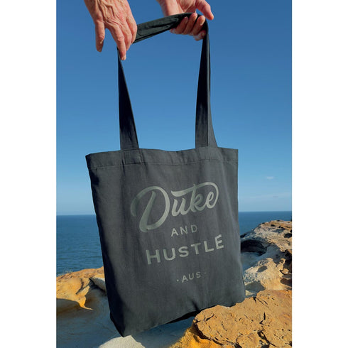 Black Premium Cotton Tote Bag with Black Vinyl Duke and Hustle Logo, hanging