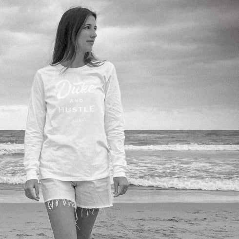 Emma wears The Flat White, white vinyl D&H logo on a white 100% cotton long sleeve unisex fit tee